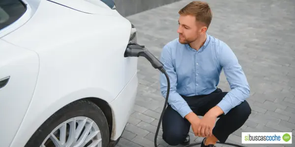 Hombre con su coche eléctrico enchufable en Galicia